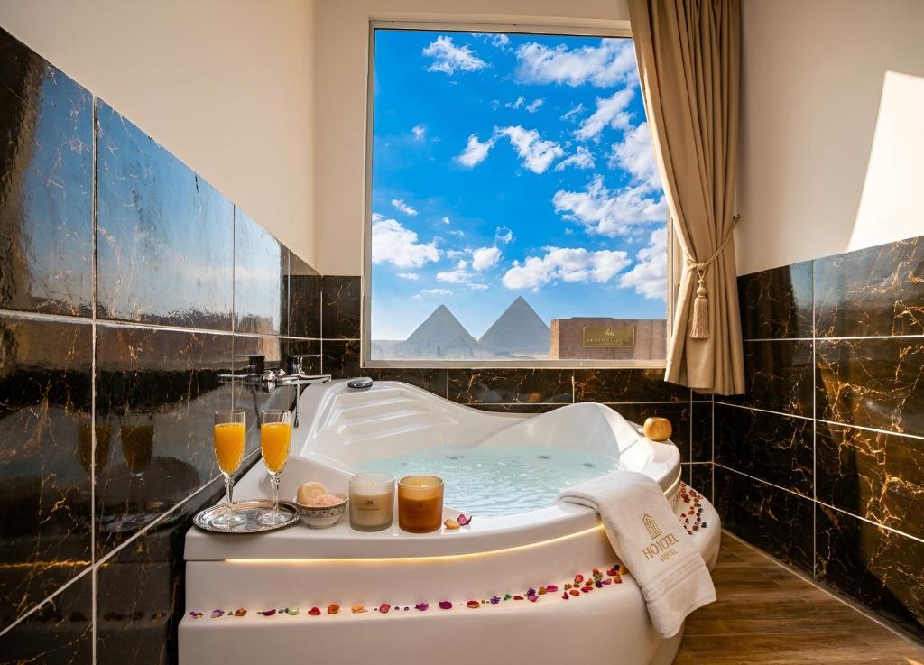 a bath tub in a bathroom with a window at Anubis Pyramids View Inn in Cairo