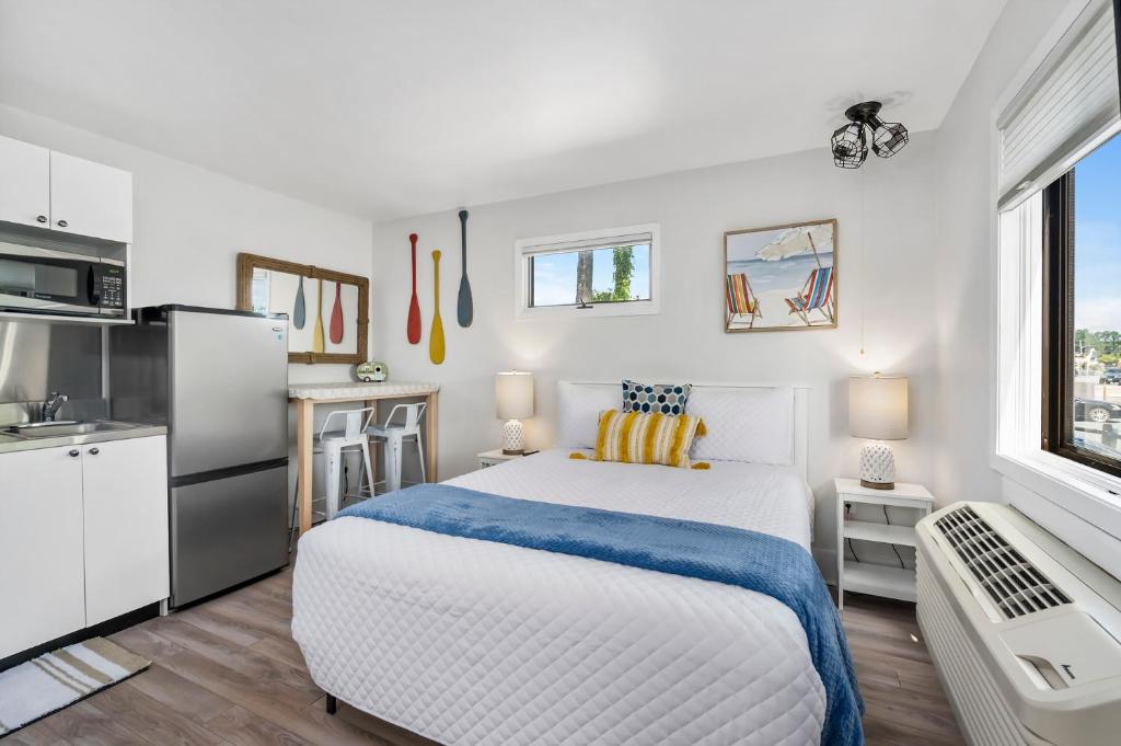 a white bedroom with a bed and a kitchen at Assateague Inn 100-2R in Chincoteague