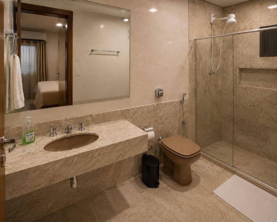 a bathroom with a sink and a toilet and a shower at Pousada Yeshua in Paracatu
