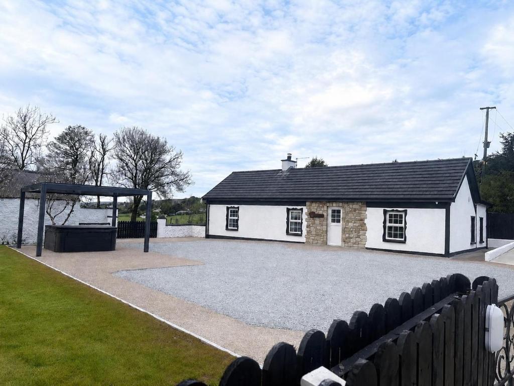 a building with a basketball hoop in front of it at Hughie Toms Cottage in Greencastle