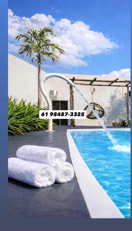 a towel laying next to a swimming pool at A Casa Piscina Quente até 50 Graus em Caldas Novas Com Sistema de Trocador de Calor e com Sauna e Ofurô Super Quente, Paradisiaca ll Com Roupa de Cama e Banho, Parcelamos em até 12x no Cartão de Crédito Sem Juros Aceitamos Pet in Caldas Novas