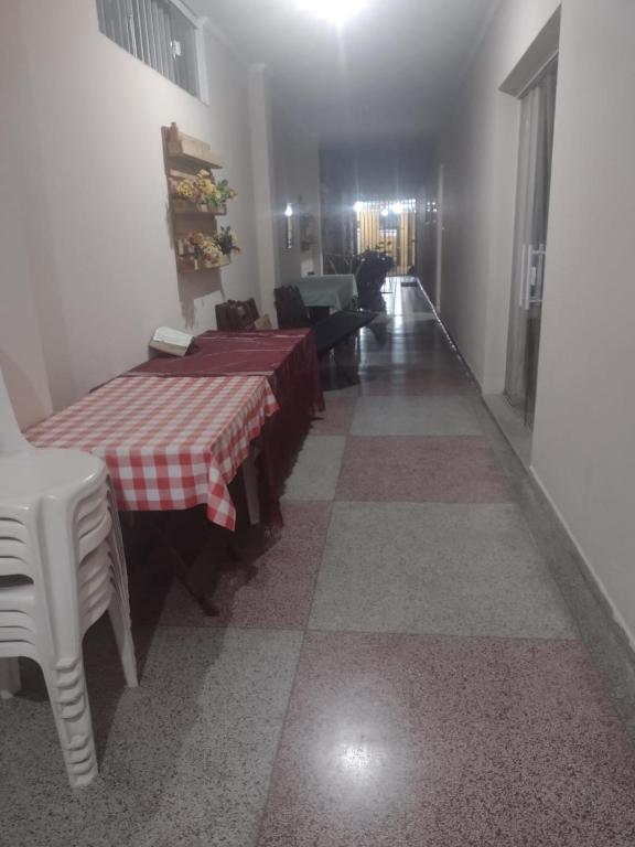 a room with a table and chairs and a hallway at Hospedaria São Francisco in Cachoeira Paulista