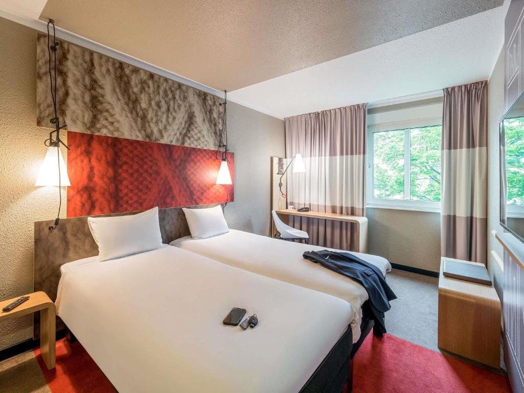 a hotel room with two beds and a window at ibis Hotel Regensburg City in Regensburg