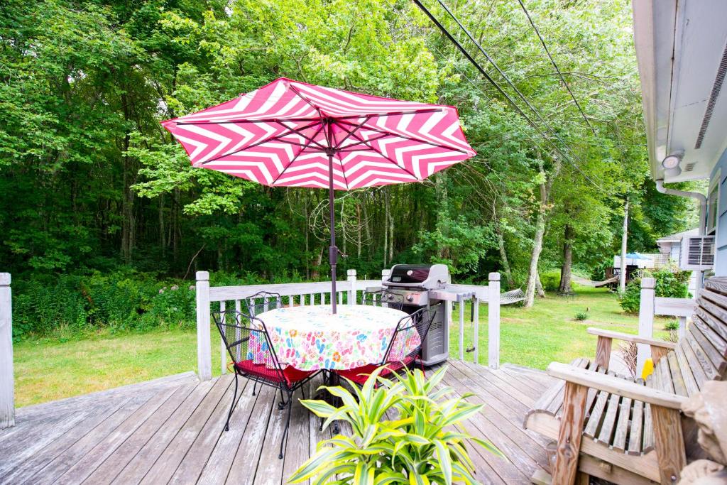 a table and an umbrella on a deck with a grill at Beach House with Spacious Deck for Entertaining in Narragansett