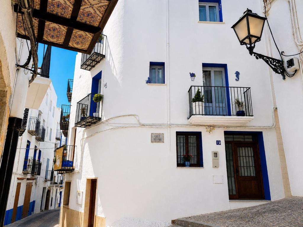 a white building with blue doors and windows at A H Rentals El Gato Azul Casa entera in Peniscola