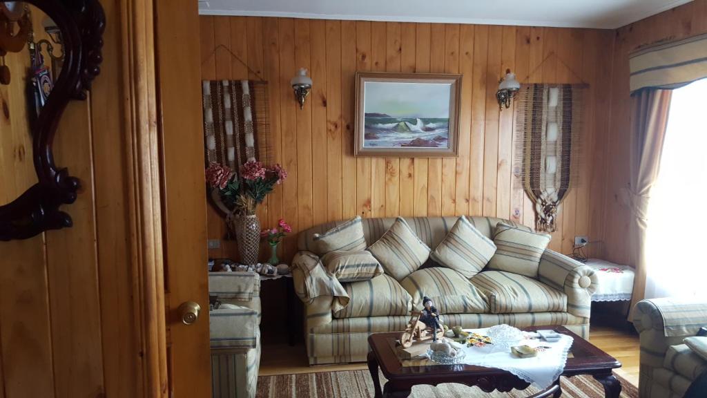 a living room with a couch and a table at Hostal Costa Azul in Castro