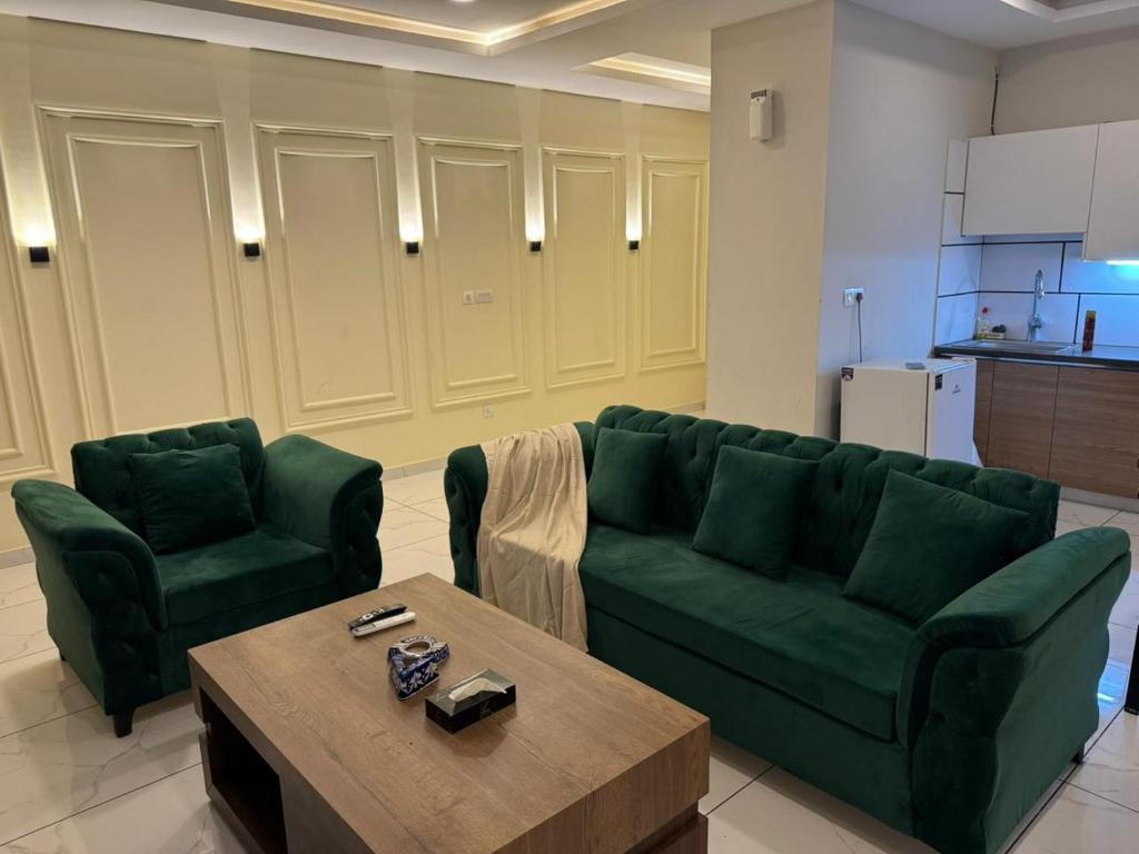 a living room with a green couch and a coffee table at Executive 2 bedrooms in Rawalpindi - Self Checkin in Rawalpindi