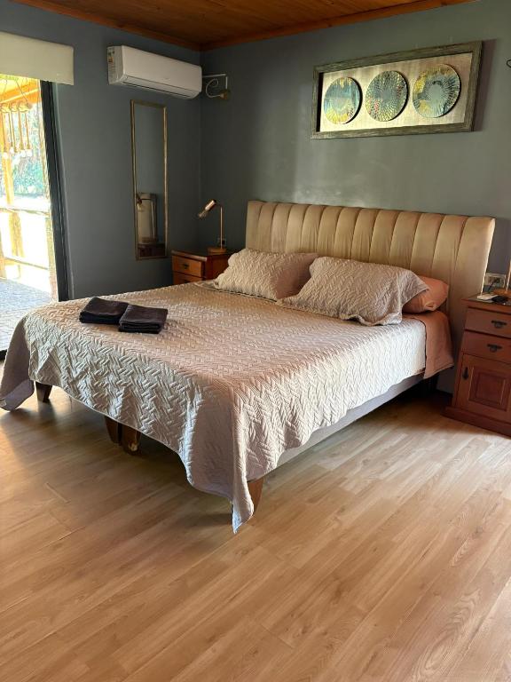 a bedroom with a large bed with a wooden floor at Habitación Suite in Chimbarongo