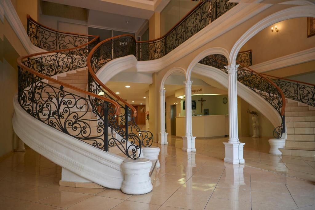 eine Wendeltreppe in einem Haus mit weißen Säulen in der Unterkunft Hotel Real Alteño in Tepatitlán