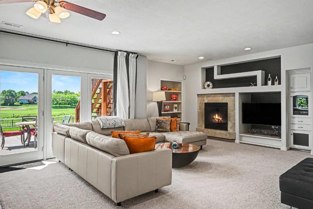a living room with a couch and a fireplace at Mulligan Manor Golf Course Views Fun Amenities in Omaha