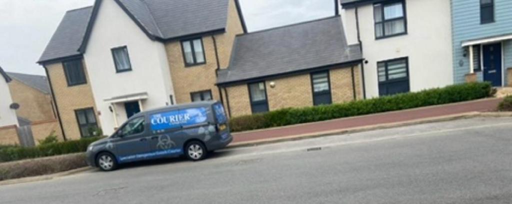 a blue van parked on the side of a street at MK WhiteHouse cottage in Milton Keynes