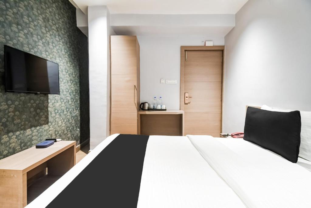 a hotel room with a bed and a flat screen tv at Hotel O Sivalika Inn in Kolkata