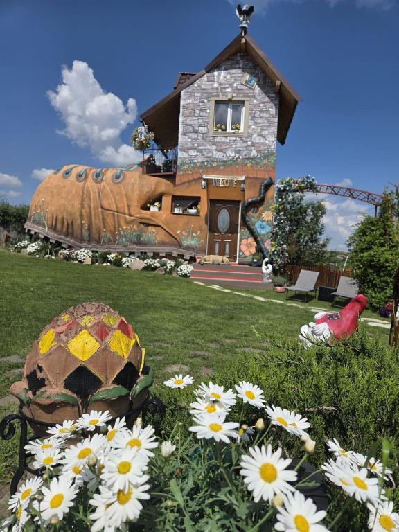 a house with a field of flowers in front of it at La Moșie in Săldăbagiu de Munte