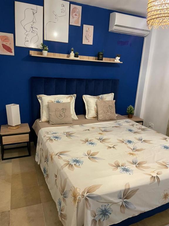 a blue bedroom with a bed with a blue wall at Charmant duplex proche mer à Carthage in Carthage