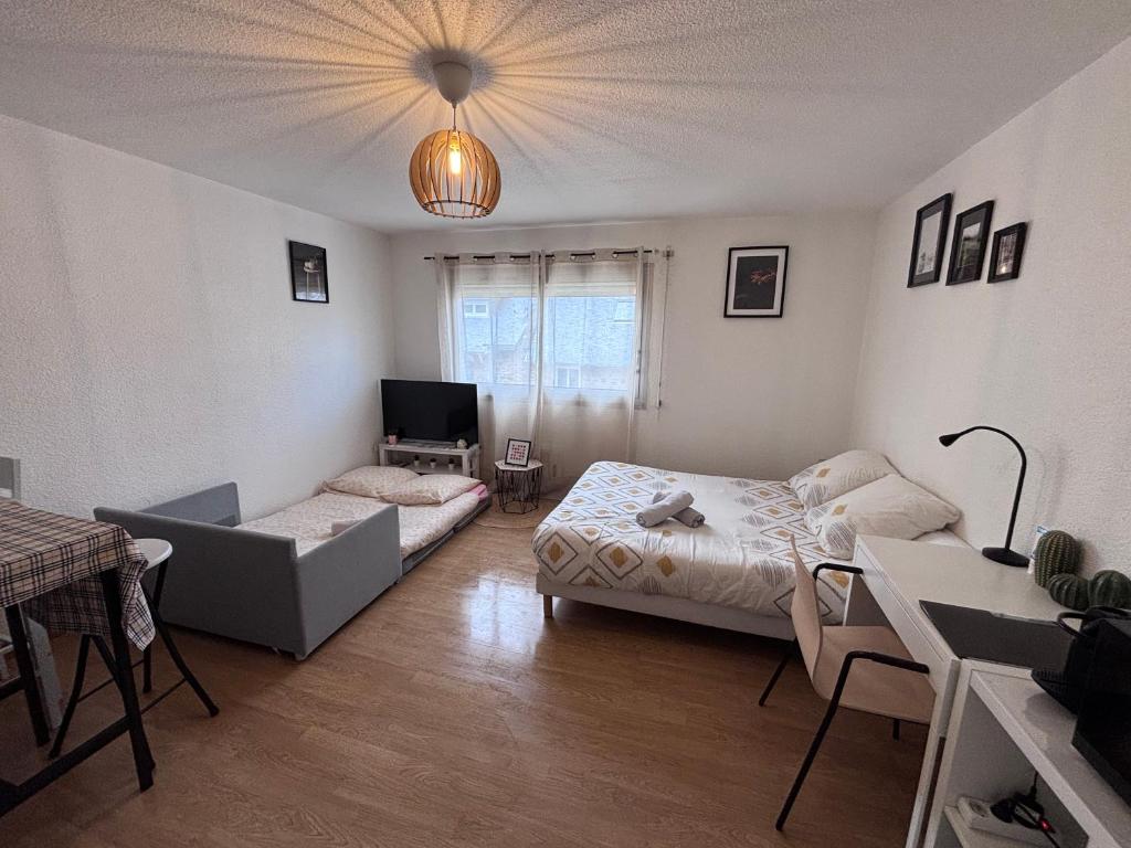 a living room with a bed and a couch at Coeur de Perros-Guirec - Studio in Perros-Guirec