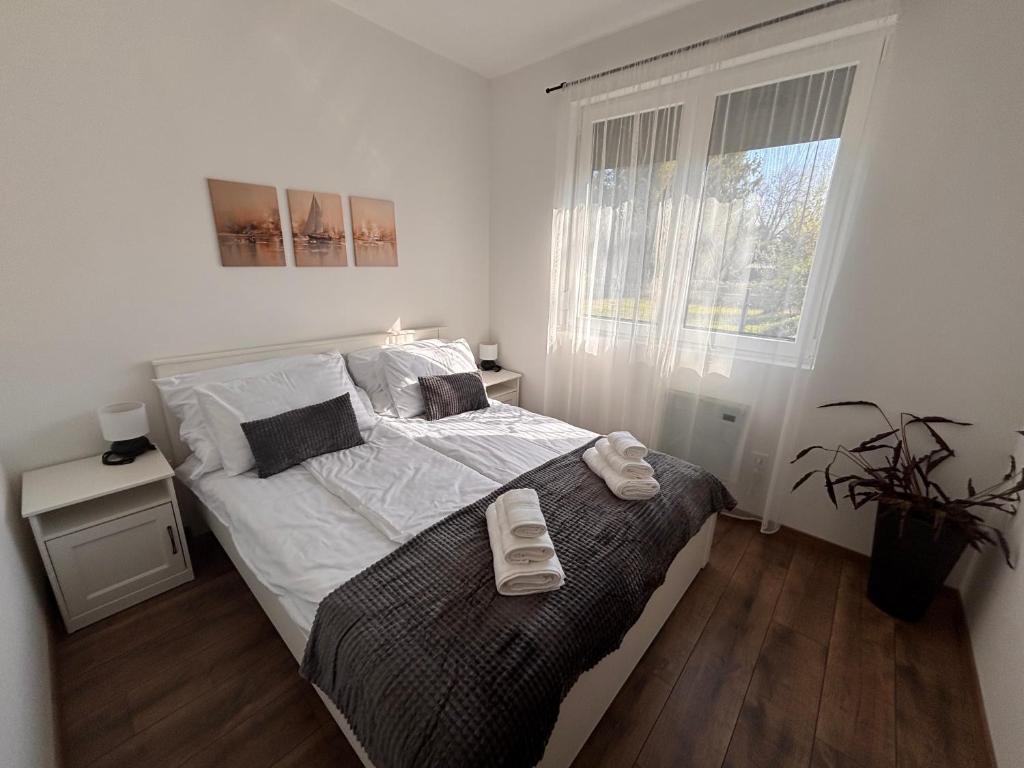 a bedroom with a bed with two towels on it at Argent apartman in Balatonmáriafürdő