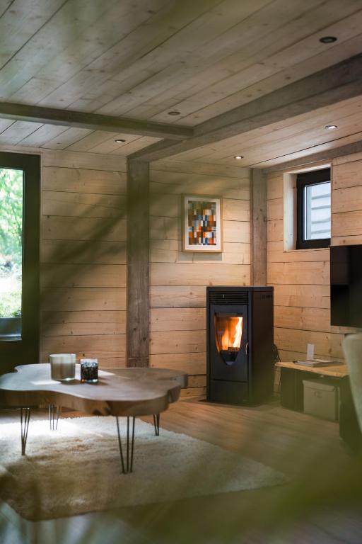 a living room with a fireplace and a table at Wood Chalet Durbuy in Durbuy