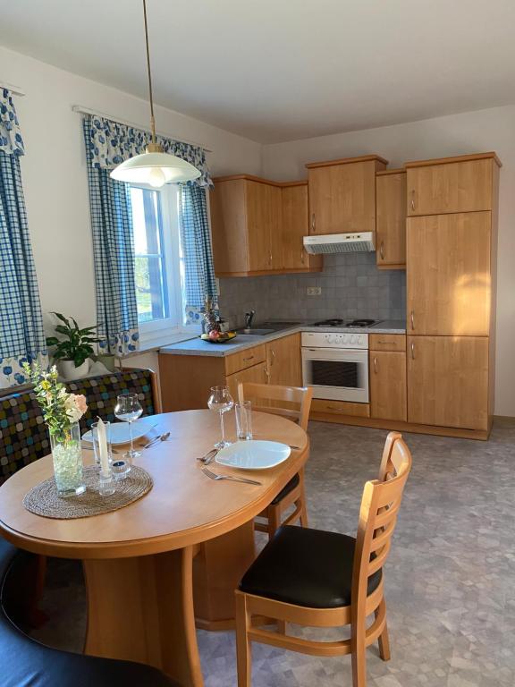 a kitchen with a wooden table with chairs and a dining room at Ferienwohnung Abendsonne in Schenkenfelden
