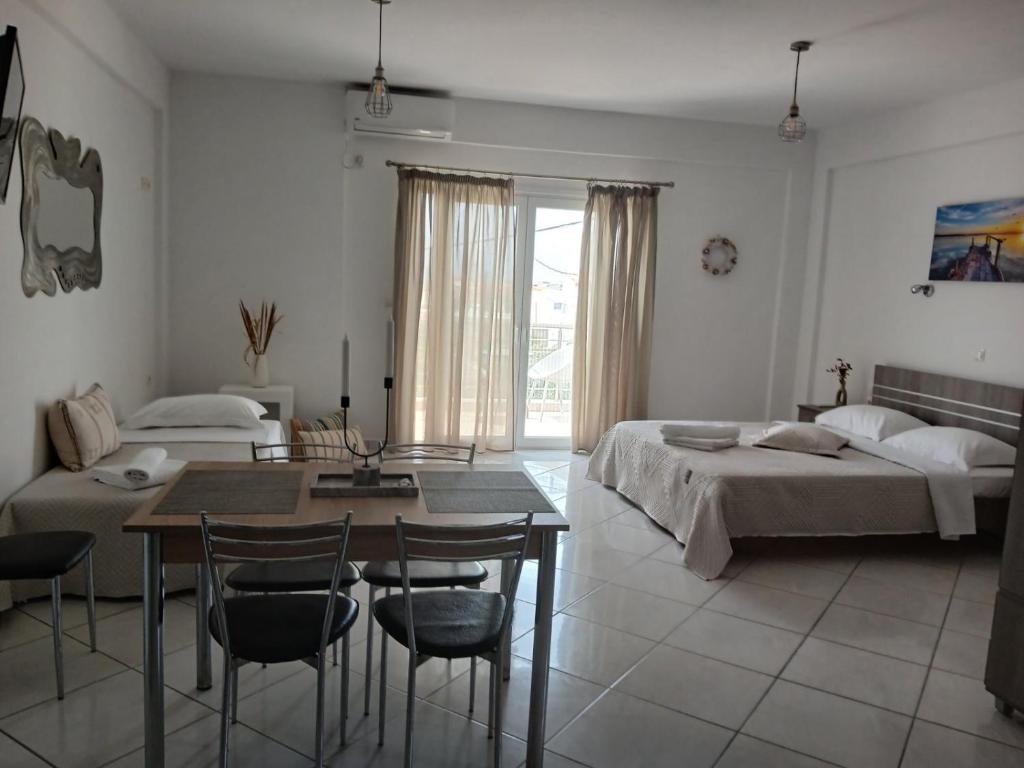 a bedroom with a bed and a table and chairs at Niko's apartments 2 in Elafonisos