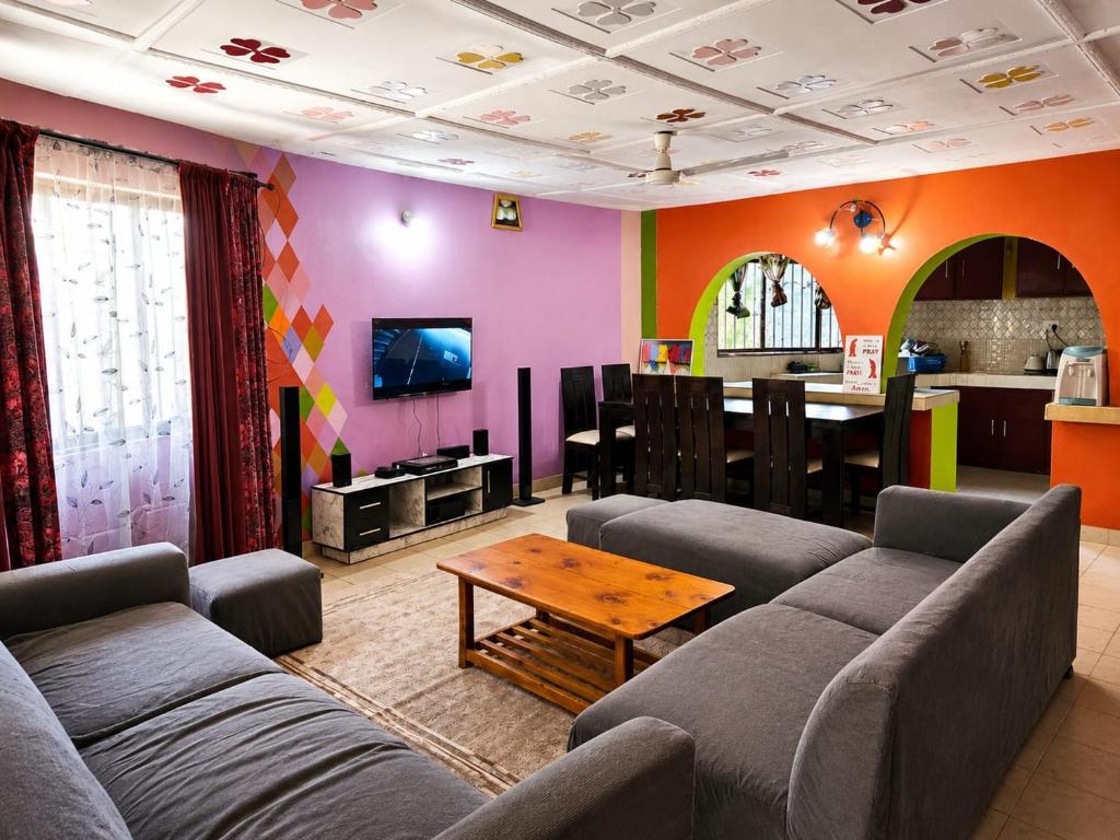 a living room with couches and a table and a kitchen at Mnchunge's Residence in Kikambala