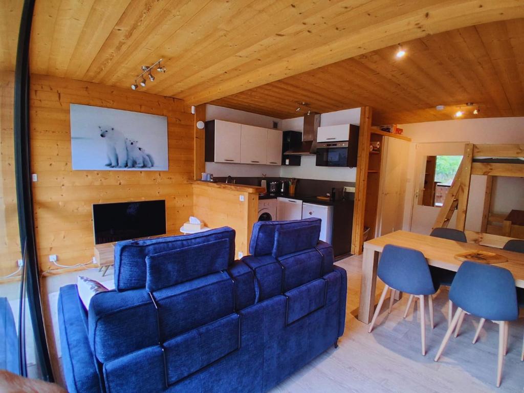 a living room with a blue couch and a table at Whitebearlodge in Arâches-la-Frasse