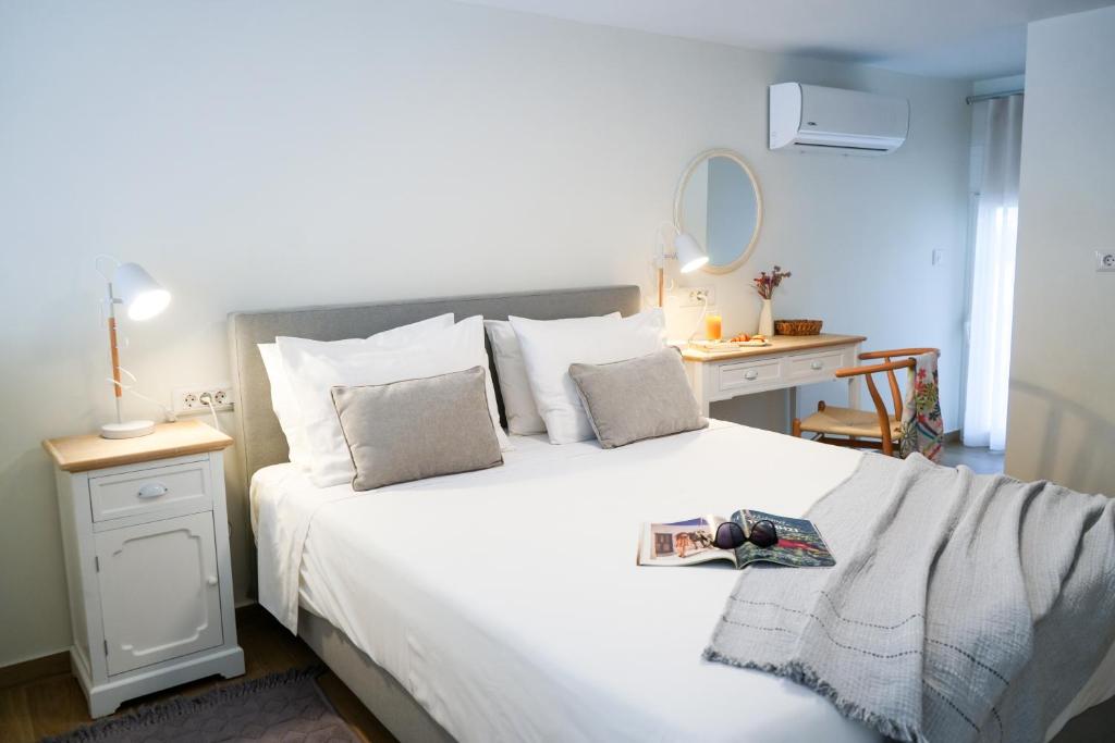 a bedroom with a large white bed and a desk at Thalassa loft in Tolo in Tolo
