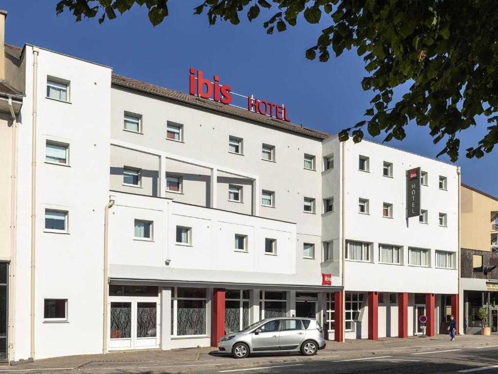 a building with a car parked in front of it at ibis Saint-Die in Saint Die