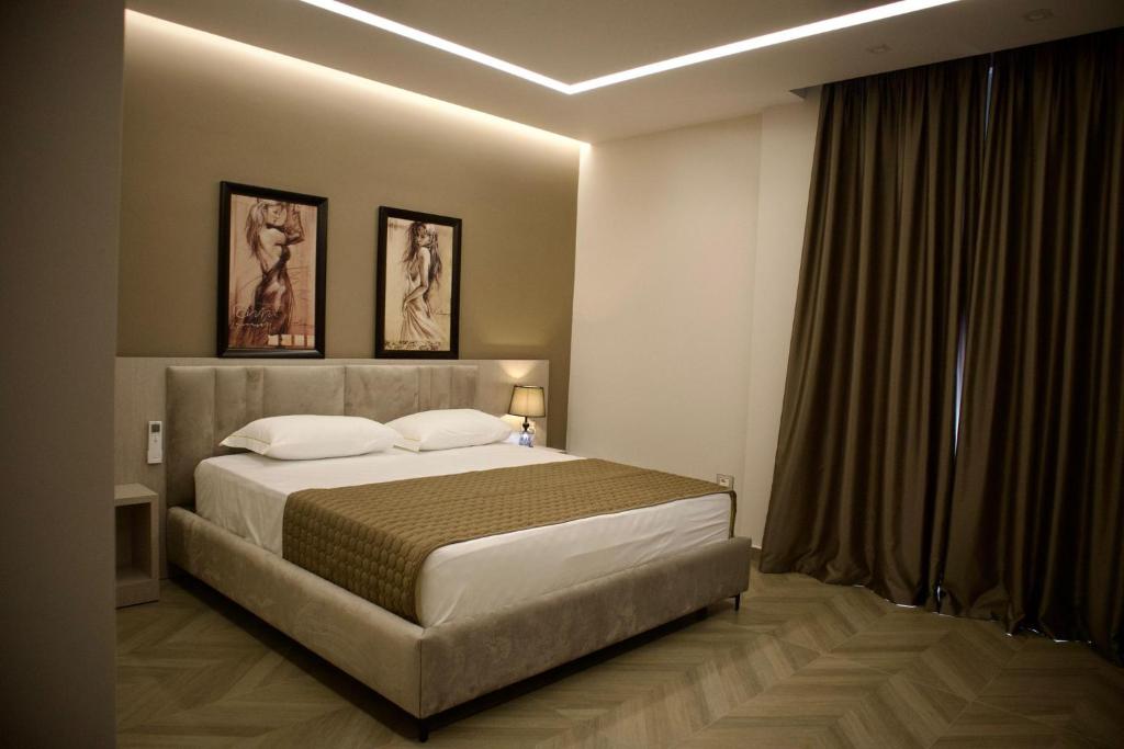 a bedroom with a large bed and a window at Rodi Hotel Elbasan in Elbasan