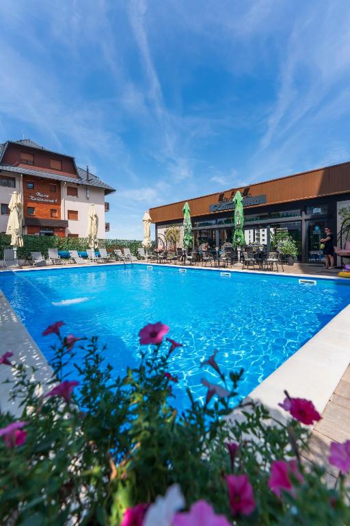 a large blue swimming pool in front of a building at Vila Katalina Spa & Resort in Zlatibor