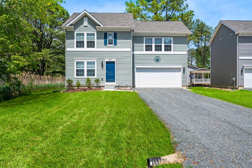 a house with a gravel driveway in front of it at Casa Playa in Greenbackville