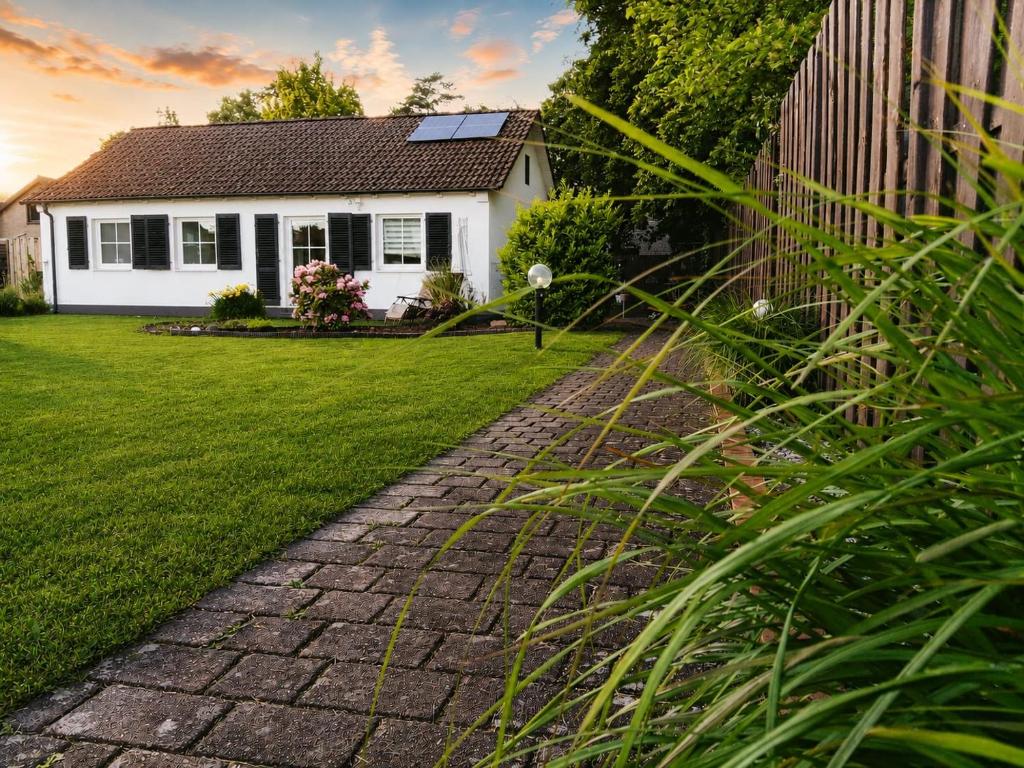 a house with a brick path in front of a yard at Ferienhaus Marion in Steinhagen
