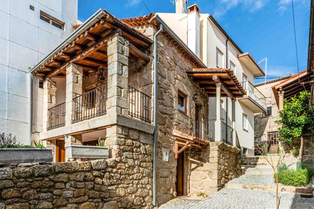 an old stone house with a stone wall at Cantinho de Caria in Caria