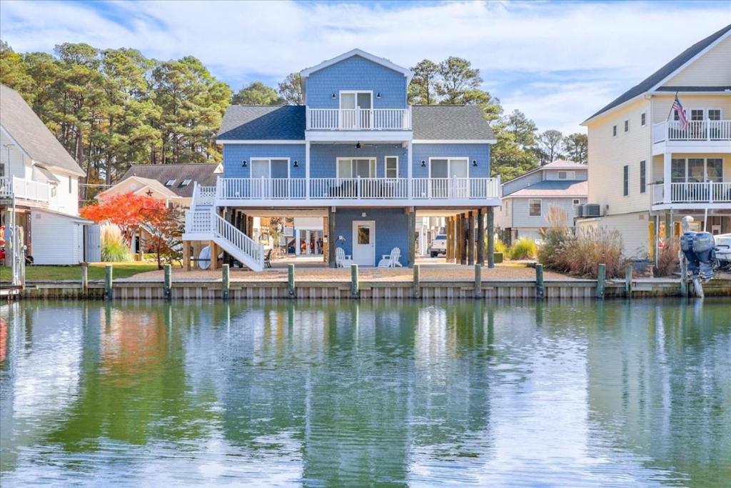 a house on a dock next to a body of water at Coastal Crab in Greenbackville