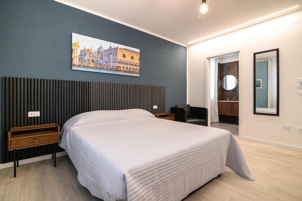 a bedroom with a white bed and a painting on the wall at Casa Di Luca in Chioggia