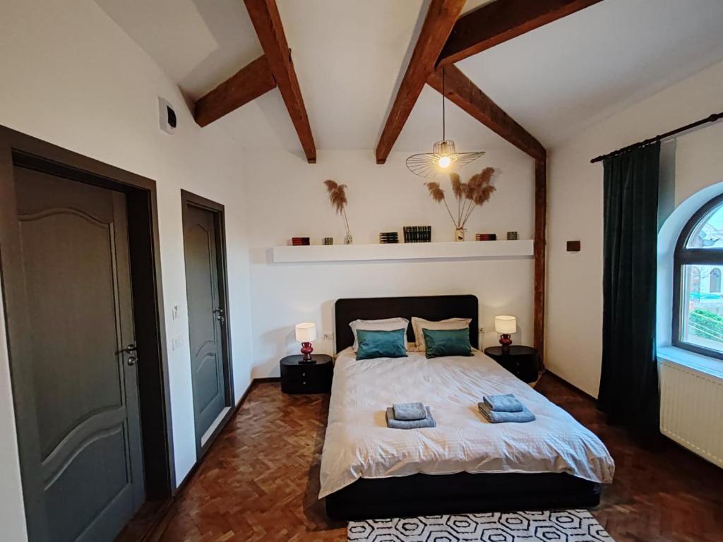 a bedroom with a large bed with two blue pillows at Vintage House Apart in Buzău