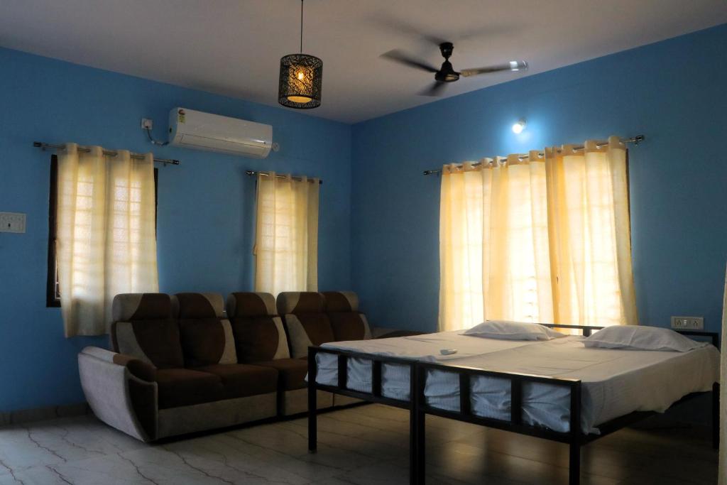 a room with a bed and a couch and windows at Yardlin Hotel in Perunkalattu