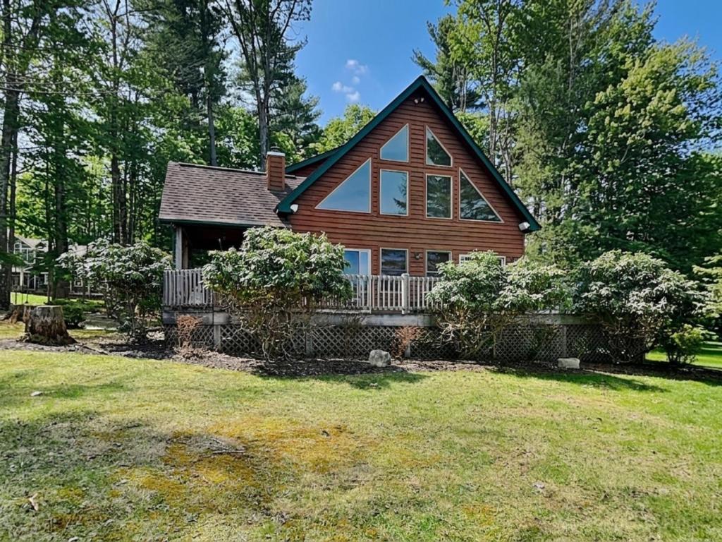 a wooden house with a fence and a yard at Almost Heaven in Swanton