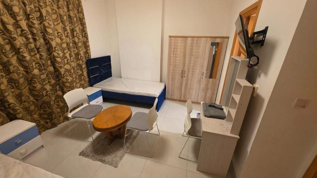 a room with a bed and a table and chairs at Relaxing bed Ajman in Ajman 