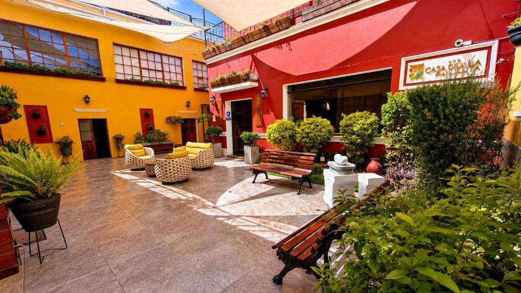 a courtyard with benches and plants in a building at Casa de Avila Hotel in Arequipa