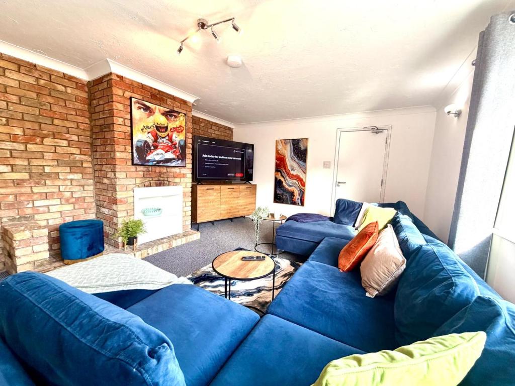 a living room with a blue couch and a brick wall at Swan View House in Littleport
