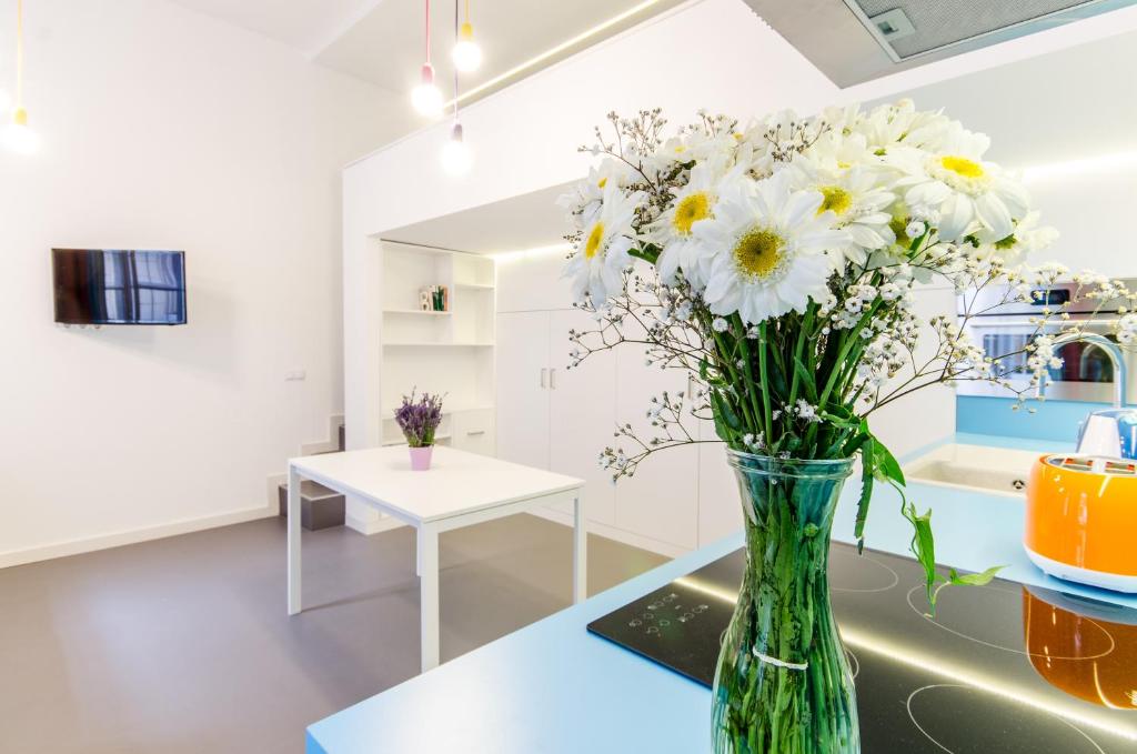 wazon wypełniony białymi kwiatami siedzącymi na stole w obiekcie Sara's Apartment w Budapeszcie