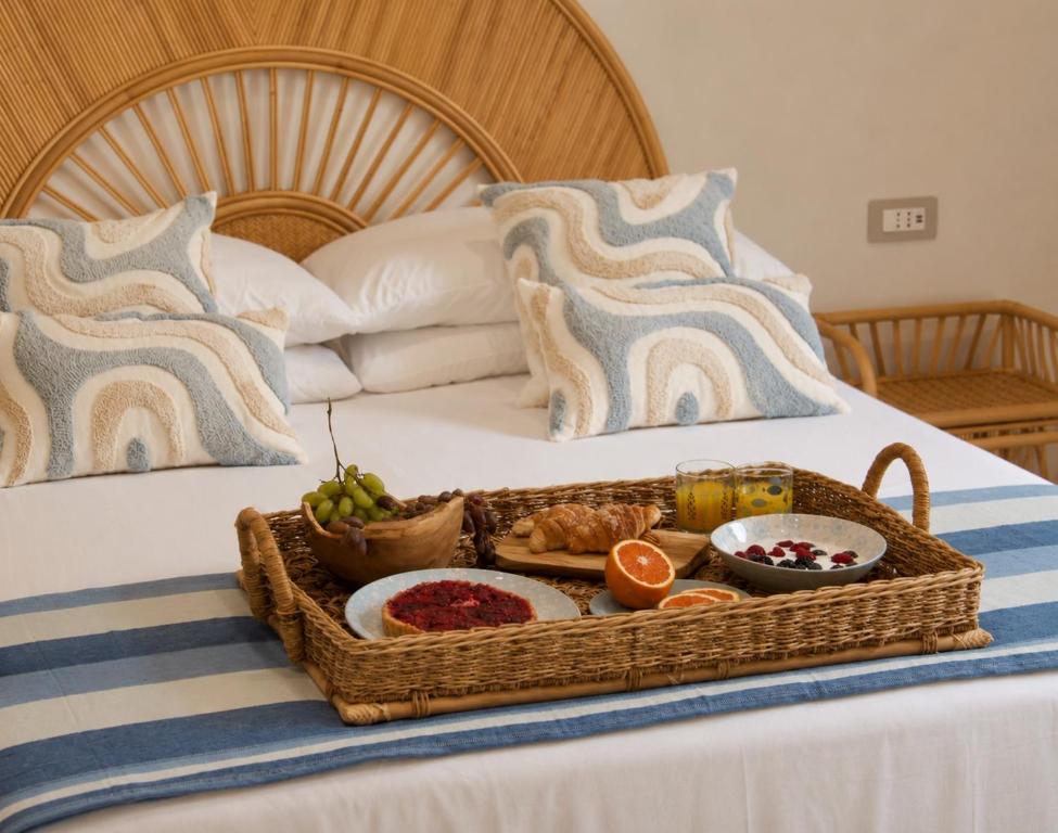 a tray of food on top of a bed at LIGEA APARTMENT - Bright Mediterranean Home with Bali-Inspired Touches - Central Anzio near Sea, Train and Bus Station in Anzio