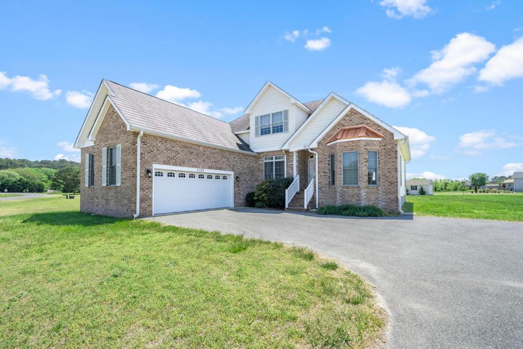 a large brick house with a white garage at Fairway Stay in Greenbackville