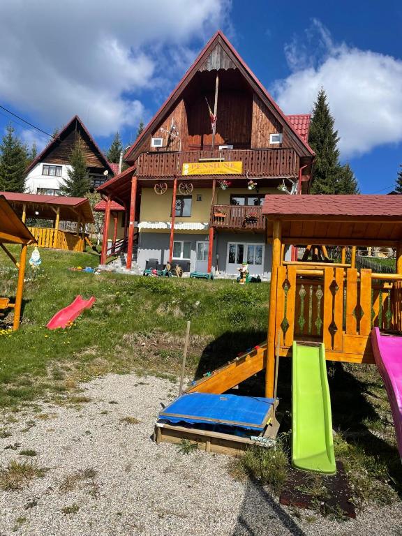 a house with a playground in front of it at Pensiunea Casa OLLY in Muntele Cacovei