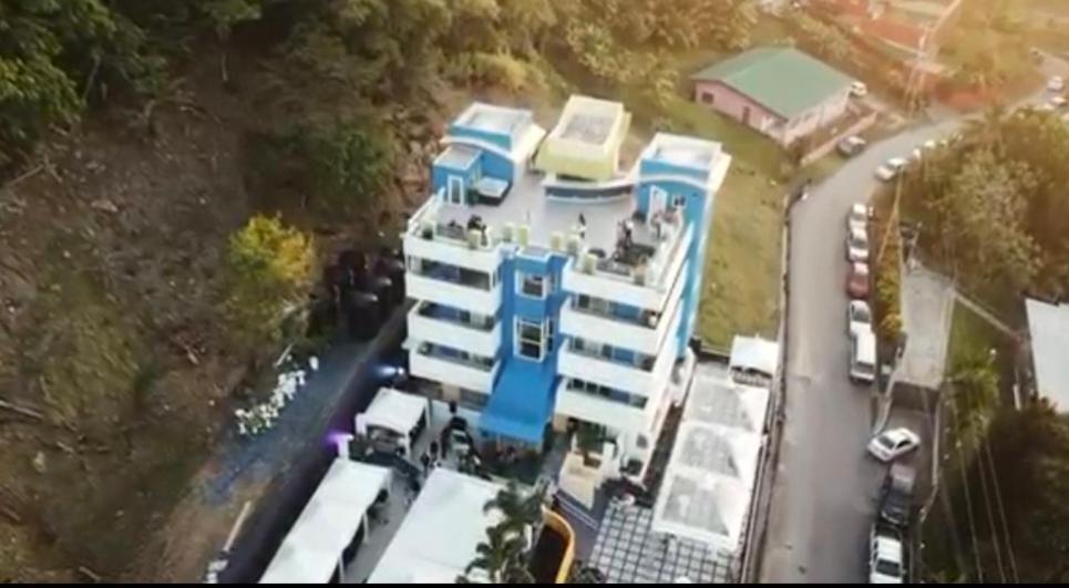 an aerial view of a building with cars parked in front at Tocopia and private house ddi in Sangre Grande