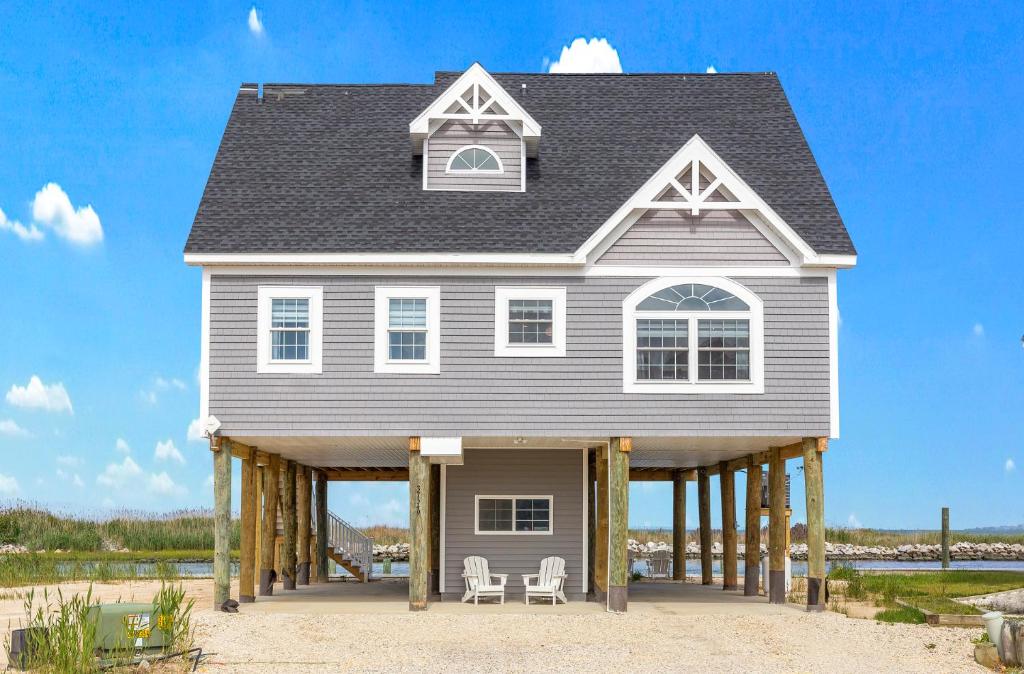 a house on a dock with two chairs at Gallops Point in Greenbackville