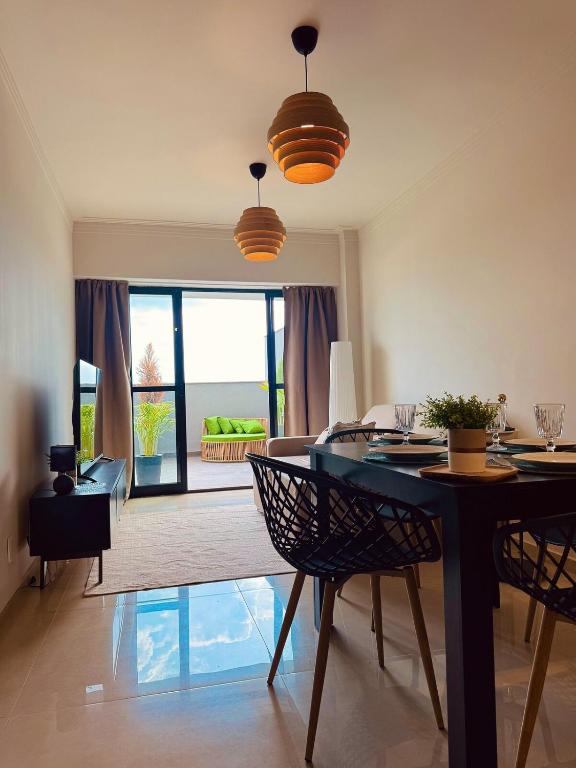 a dining room with a table and chairs in a room at Apartamento Sofisticado com terraço centro Pouso Alegre in Pouso Alegre