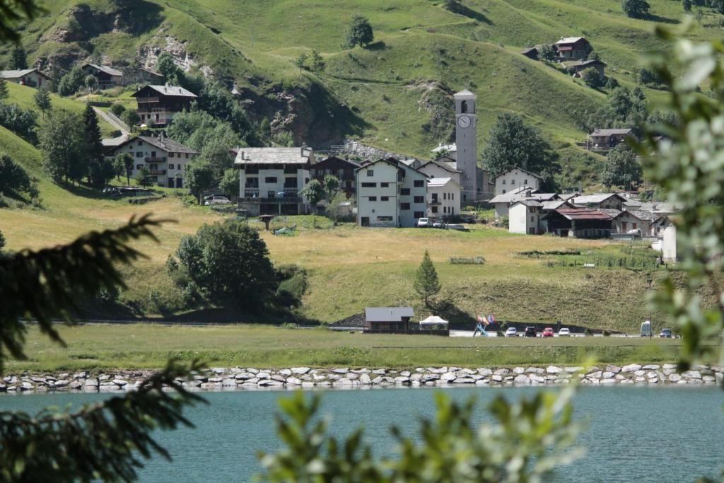 uma pequena aldeia ao lado de um lago em Albergo Mangusta em Madesimo