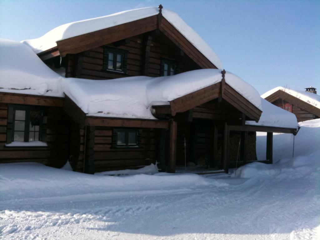 a log cabin with snow on top of it at Utsikten in Vågsli