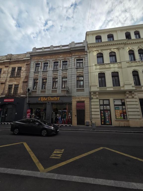 a black car parked in front of a building at Ralf Residence in Bucharest